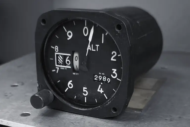 Aircraft altimeter with a barometric setting window on a metal workbench