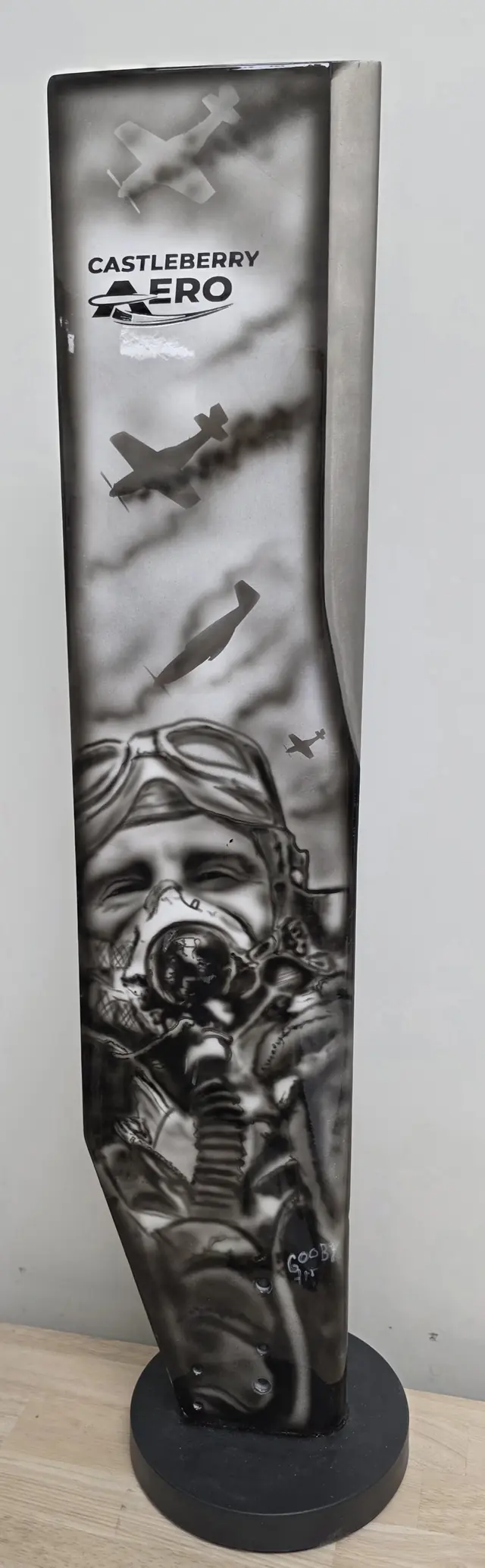 Painted propeller blade art piece standing on a display base