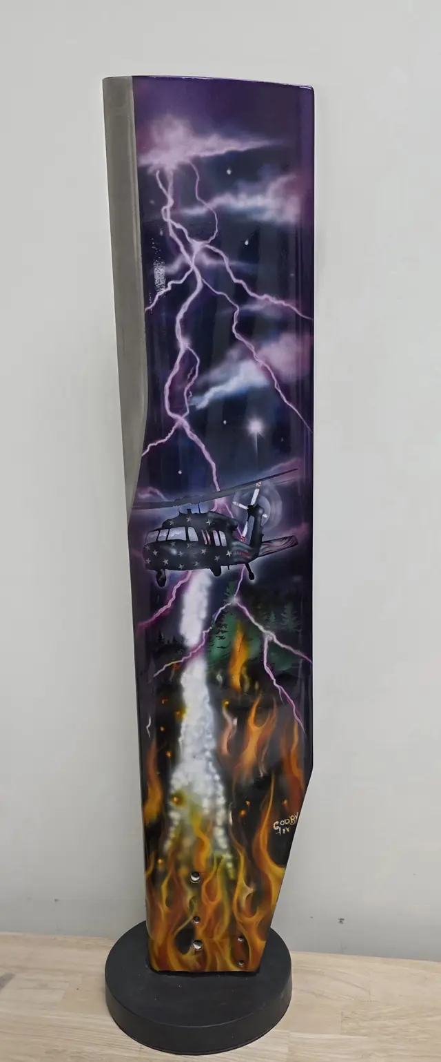 Painted rotor blade art piece standing on a display base