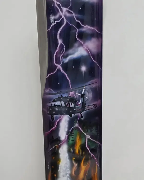 A rotor blade section painted with lightning, a helicopter and flames